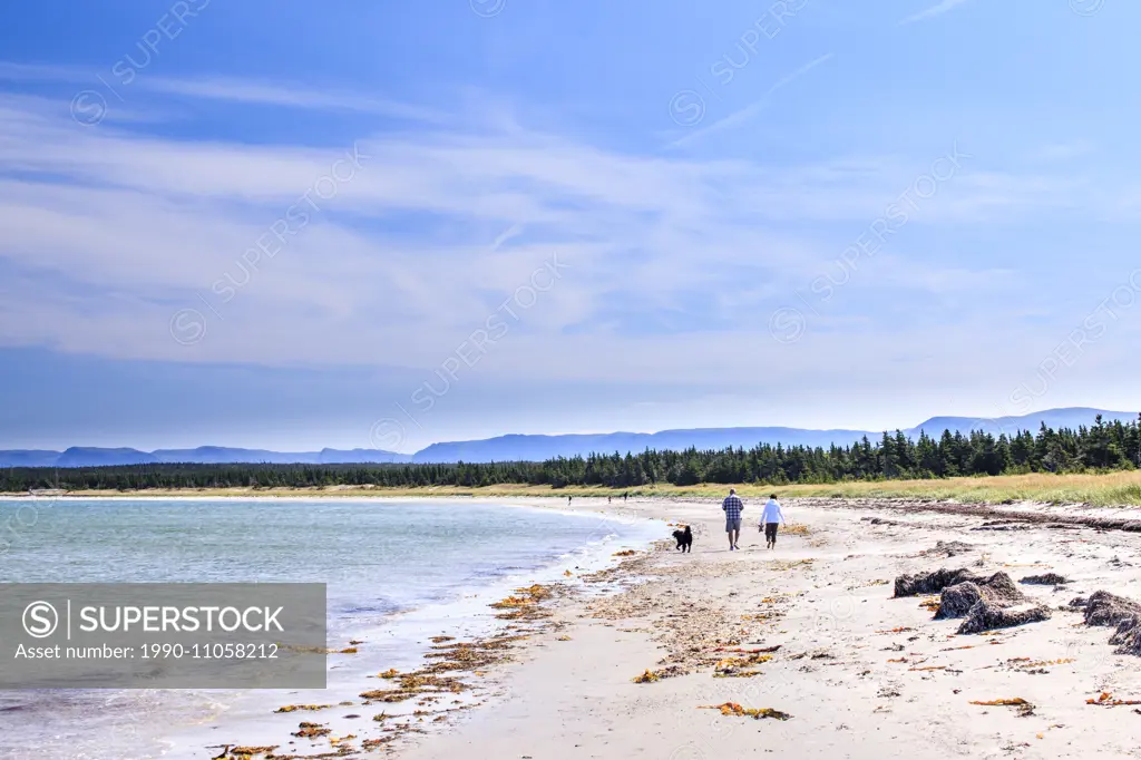 Male and female walk on the beach at Shallow Bay, Gros Morne National Park, Newfoundland and Labrador.