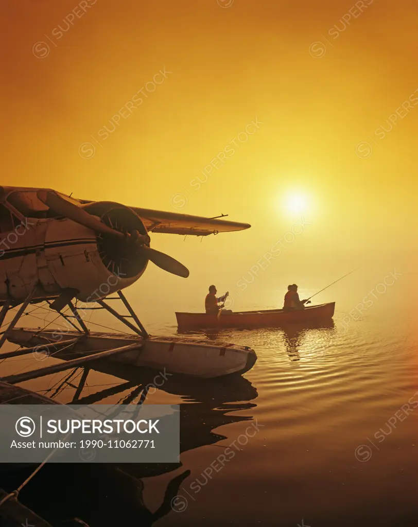 couple canoeing and fishing next to float plane dock, Manitoba, Canada