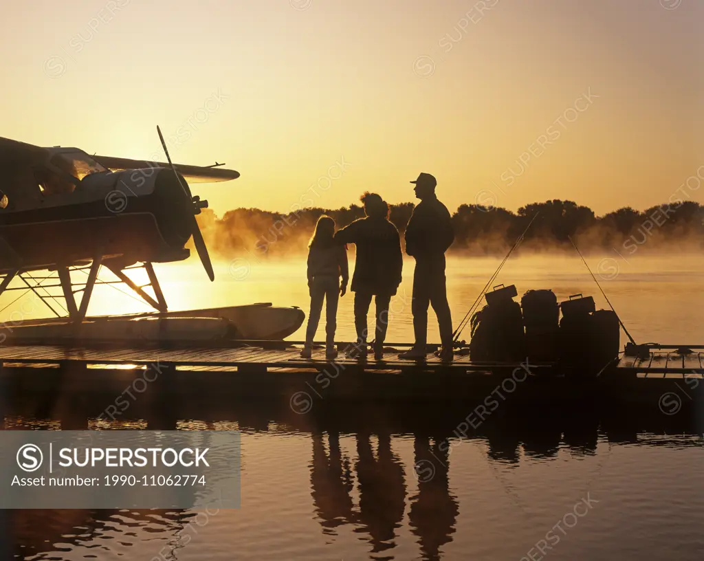family on float plane dock, along Red River, Manitoba, Canada