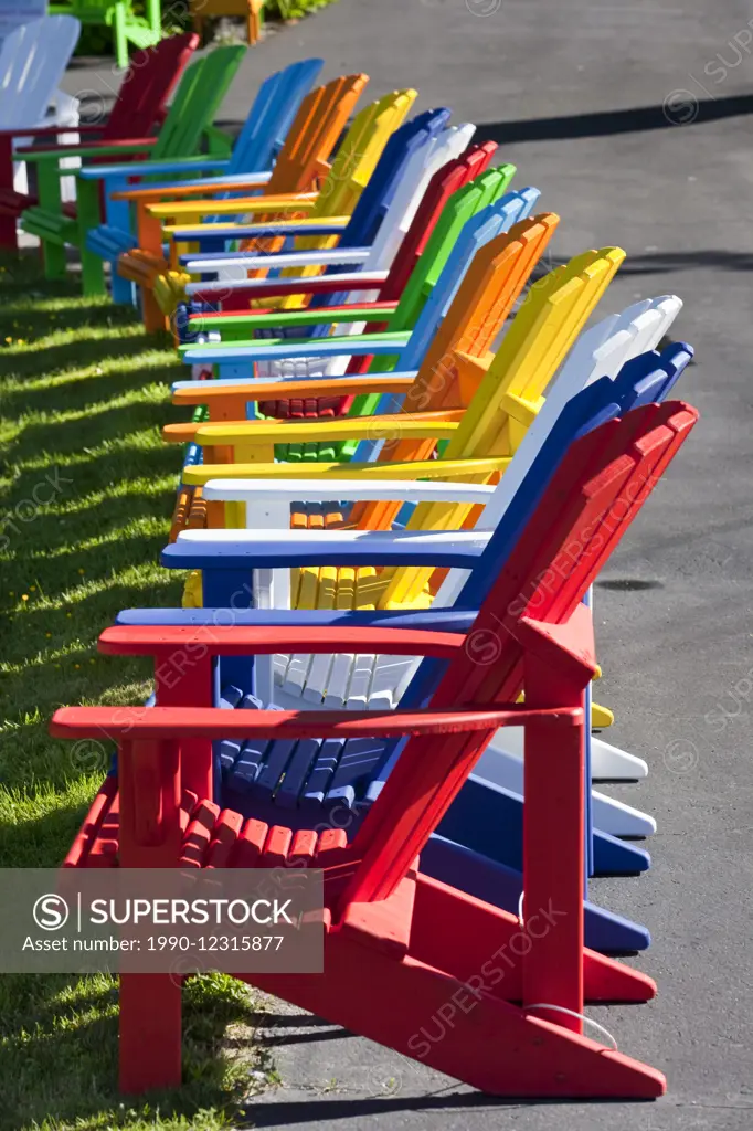 Row of brightly coloured Adirondack chairs offered for sale at the home-based business 'Add a Ron Deck Chair' in Dayspring, Nova Scotia