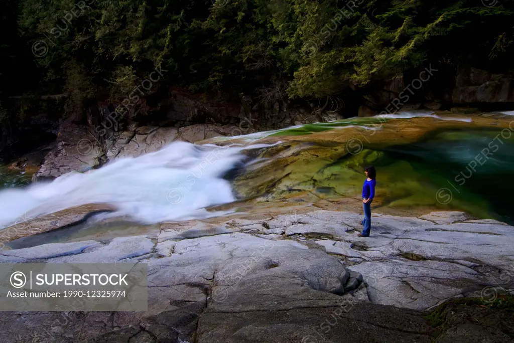 Hiker takes in the waterfall view of Gold Creek in Golden Ears Provincial Park, British Columbia, Canada. MR101