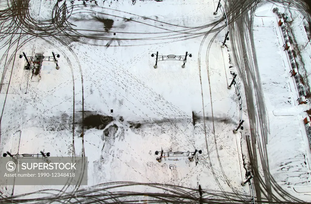 Footsteps and Car Tracks in a Snowy Parking Lot in Downtown Calgary, Alberta, Canada