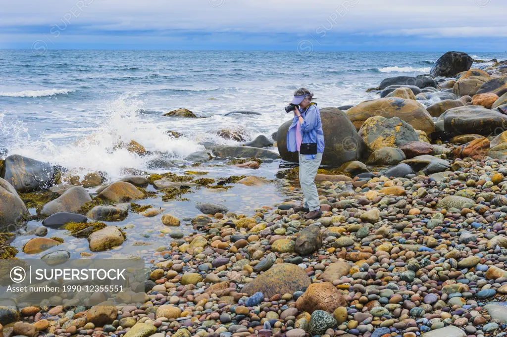 Tourist photographs incoming Atlantic Ocean waves in Gros Morne National Park, Newfoundland. Canada. MR