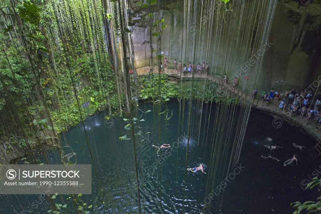 Tourists swimming in Ikil cenote on Yukatan peninsula in Mexico