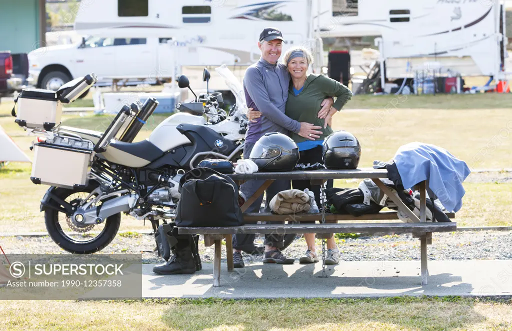 a happy mature couple packs up their campsite in preparation for a days ride on the North Island.