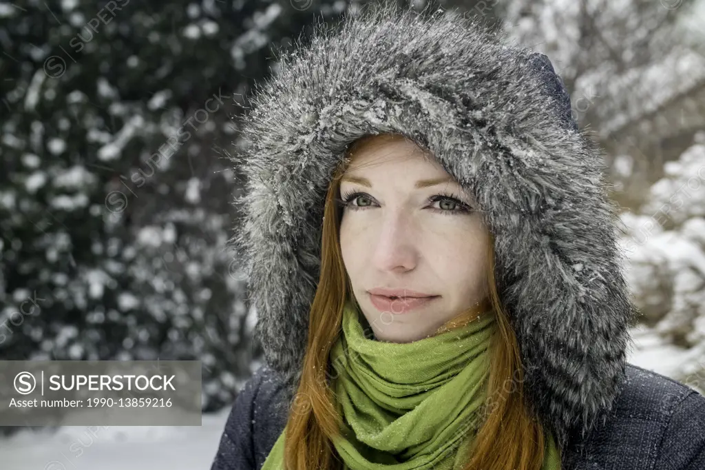 Woman (40) outdoors in winter snowfall.