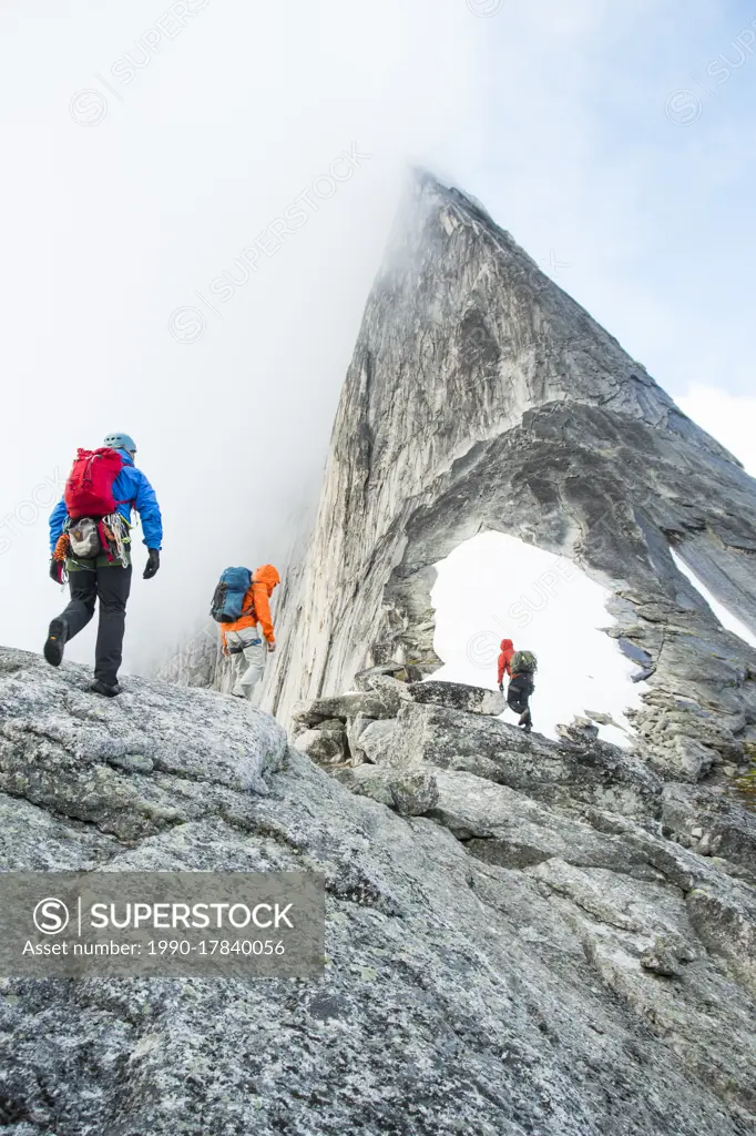 Three alpine climbers approach Bugaboo Spire for an ascent of the classic northeast ridge, British Columbia