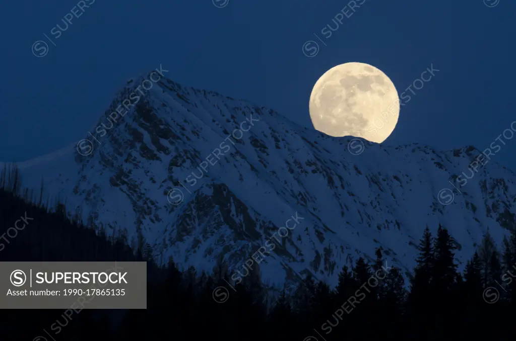 Full moon over the Canadian Rockies near Canal Flats, British Columbia