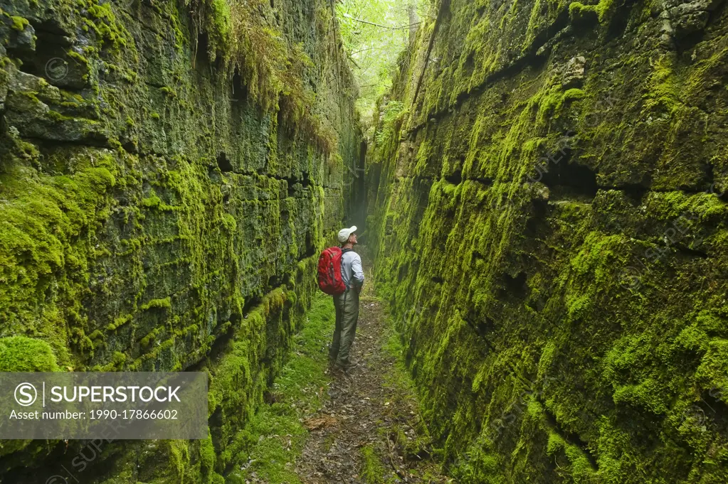 hiker along limestone fissures, Lake Winnipeg, Manitoba, Canada