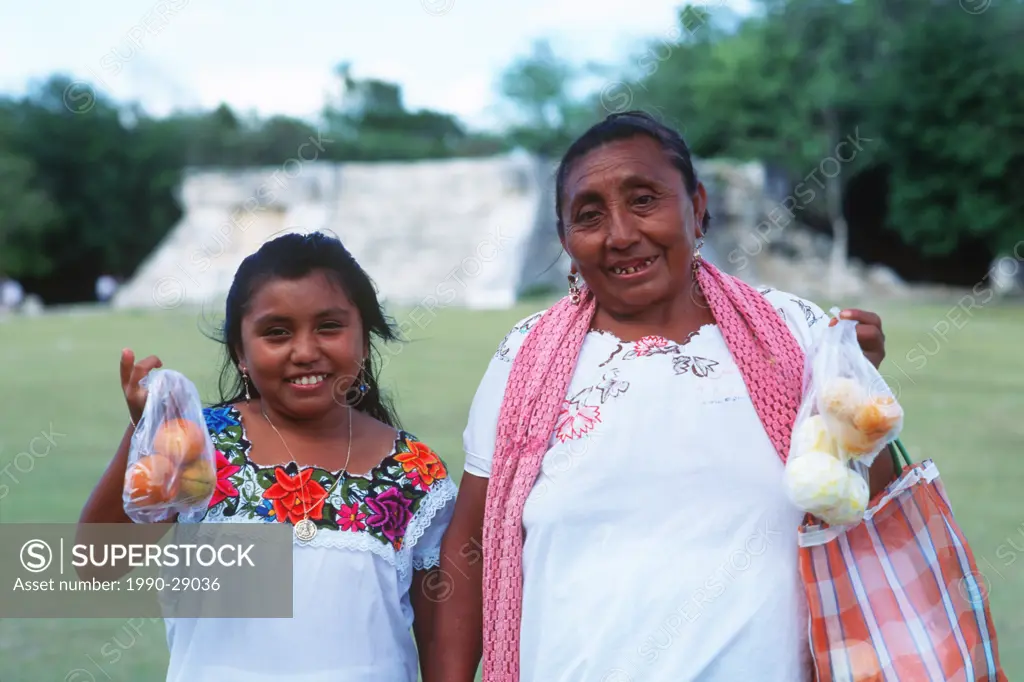 Mexico, Yucatan Peninsula at Chichen Itza, local mayan woman and girl selling oranges