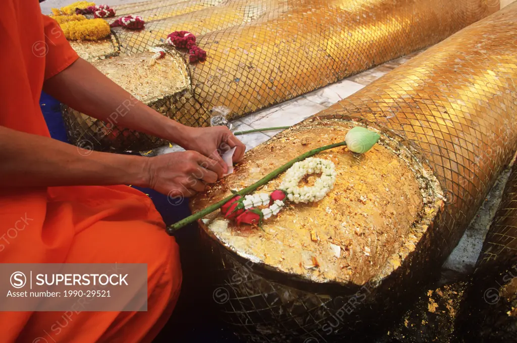 South East Asia, Thailand, Bangkok, Monks places offering at Buddha statue feet. Wat Indrawahim