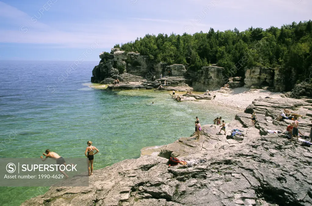 Swimmers enjoy the cool blue waters of Georgian Bay at Indian Head Cove, Bruce Peninsula National Park, Ontario, Canada