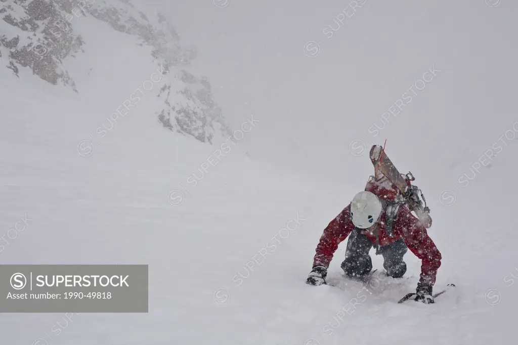 A middle aged man bootpacks up the famous Aemmer coulior on Mt Temple, Lake Louise, Banff National Park, Alberta, Canada