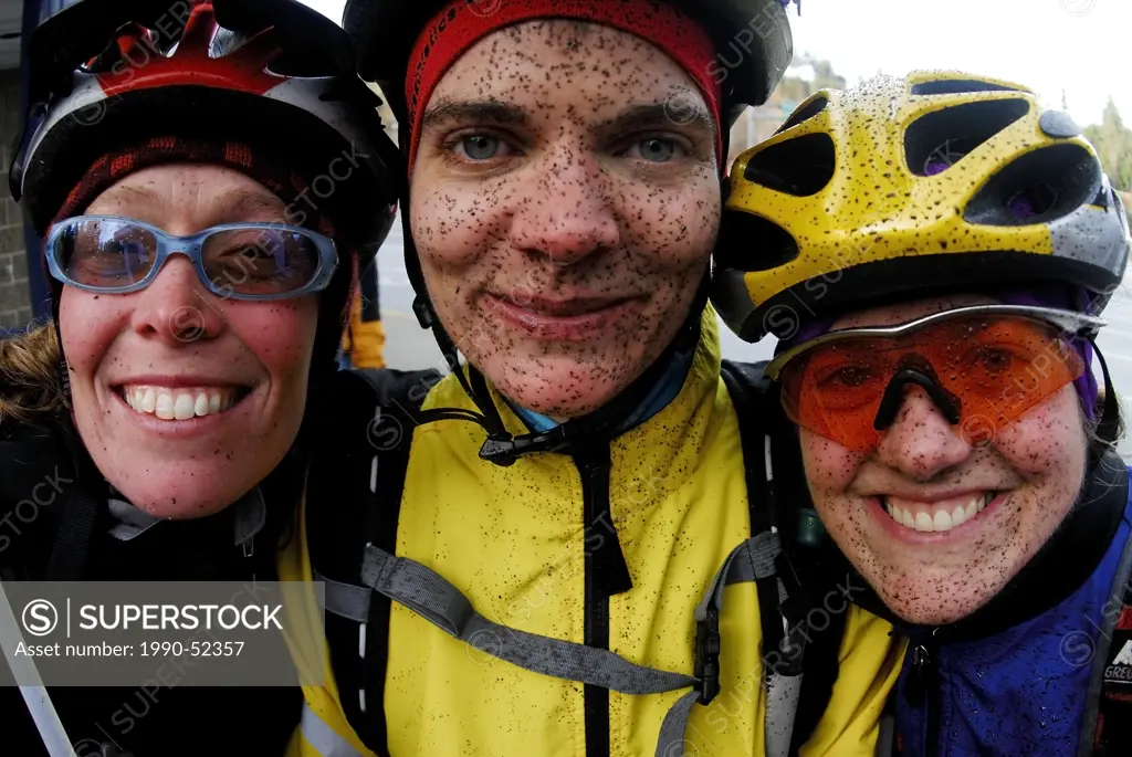 Three young women with muddy faces after mountain biking, Sunshine Coast trails. Gibsons, British Columbia, Canada.