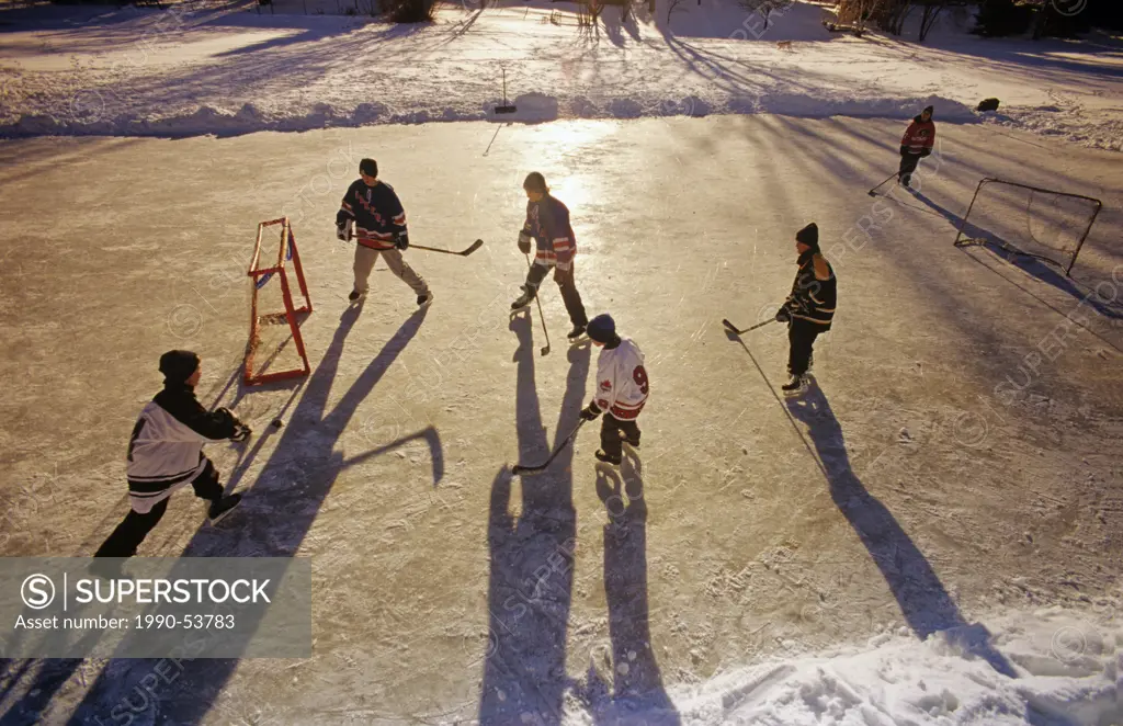 Boys playing hockey on outdoor rink, Winnipeg, Manitoba, Canada.