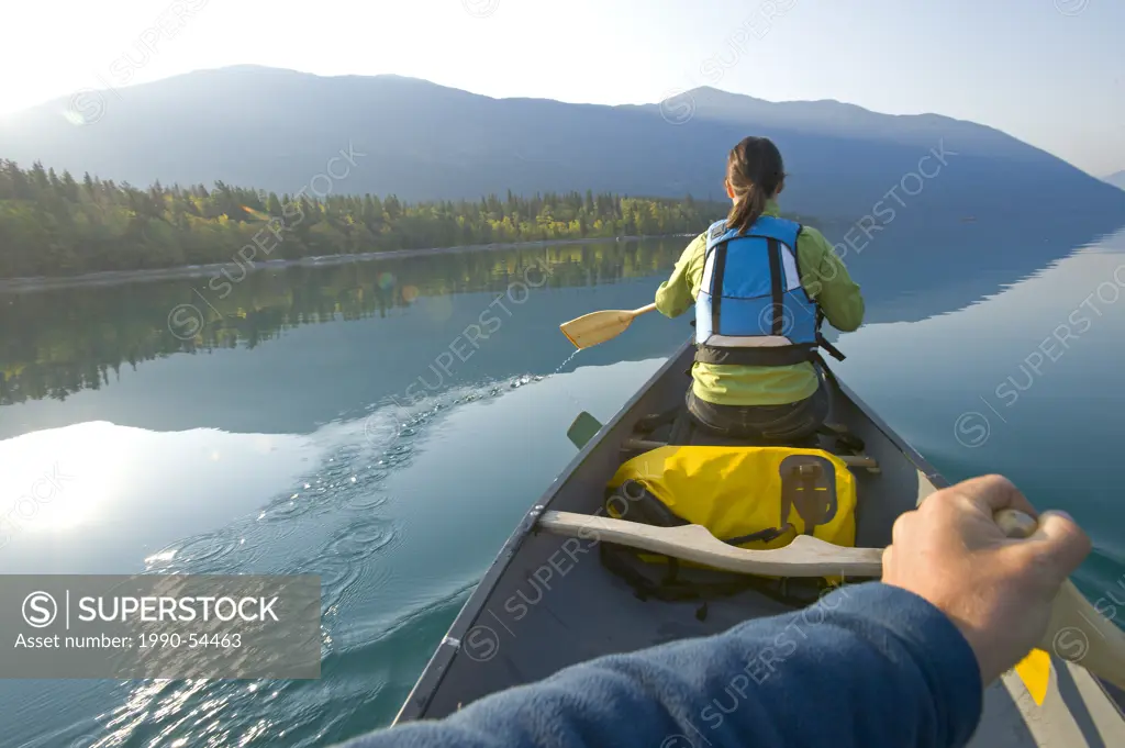 Paddling a canoe on an autumn morning on Chilko Lake, British Columbia