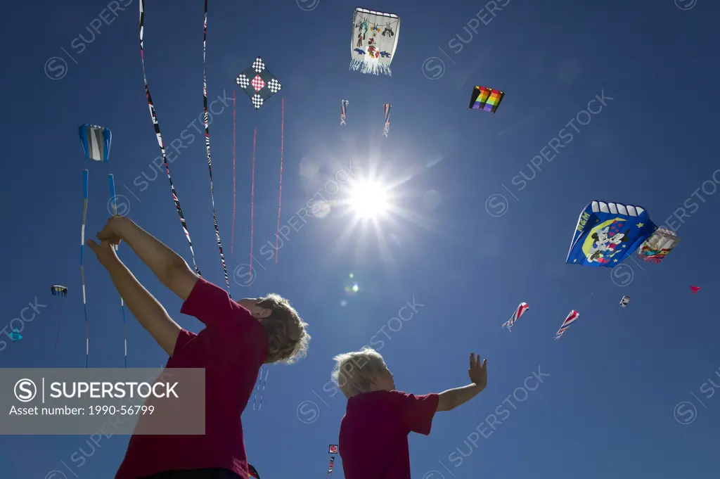 Two boys enthralled with the variety of kites at Parksville´s Kitefest, look skyward, Parksville, Central Vancouver Island, British Columbia, Canada.