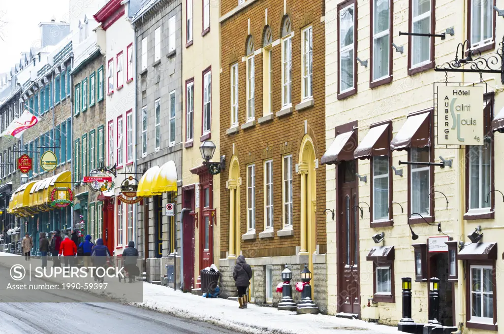 Tourists walking on an old street with Heritage commercial buildings in the Old Quebec in winter, Canada