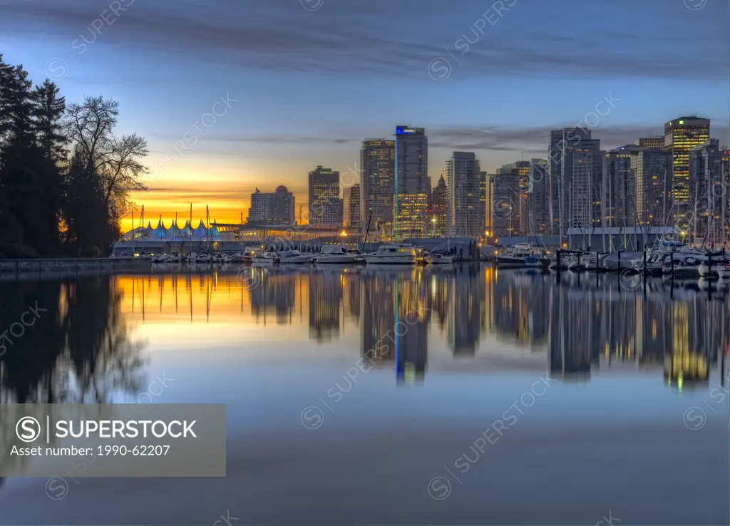 Vancouver city reflecting in Coal Harbour at Stanley Park before sunrise. The Olympic flame is visible near the centre of the image, Vancouver, Britis...