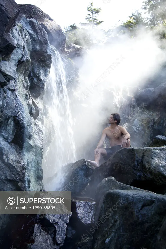 A visitor enjoys the steaming and natural mineral hot springs at Hot Springs Cove in Maquinna Provincial Park on Vancouver Island near Tofino, British...