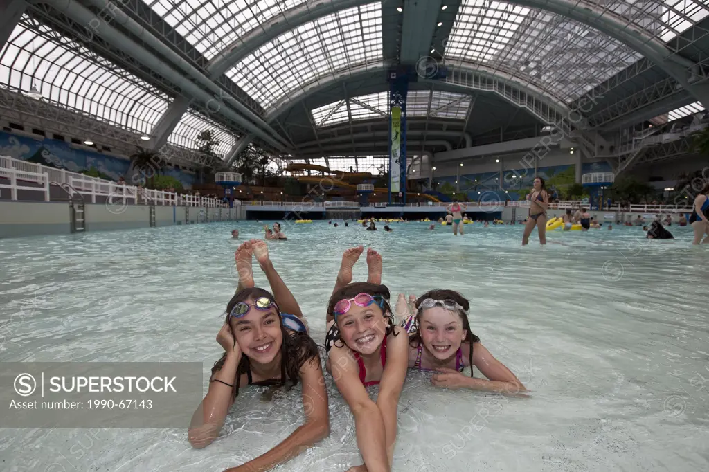 Three young girls having a great time in the waterpark at the West Edmonton Mall, Edmonton, Alberta, Canada.