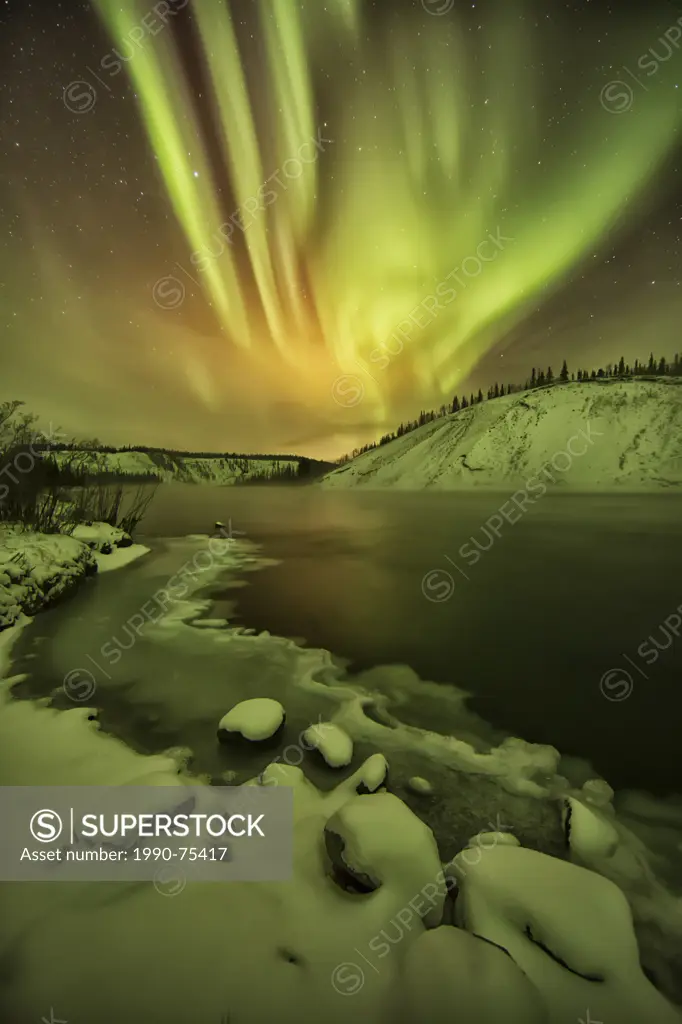 Aurora borealis light up the night sky over the Yukon River in the Yukon. Also known as the northern lights.