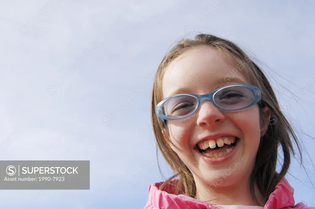 Young girl age 8 wearing funky glasses smiling, Camrose, Alberta, Canada