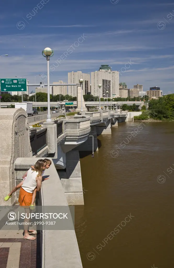 Young mother and daughter enjoy view of Red River from Norwood Bridge, Winnipeg, Manitoba, Canada.