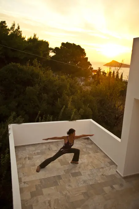 a young woman does yoga outside her studio while on a climbing trip to Kalymnos, Greece