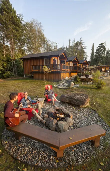 Friends gather around a fire while staying at the Ecoscape Cabins facility located in Port Hardy