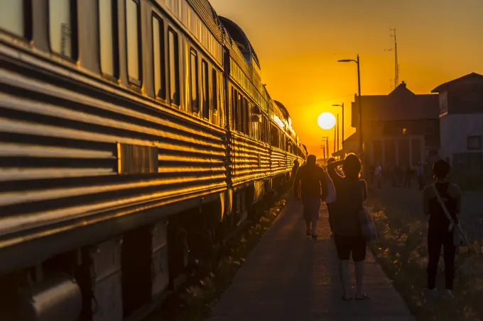 Sun setting in front of passenger train stopped in the town of Melville in Saskatchewan, Canada.