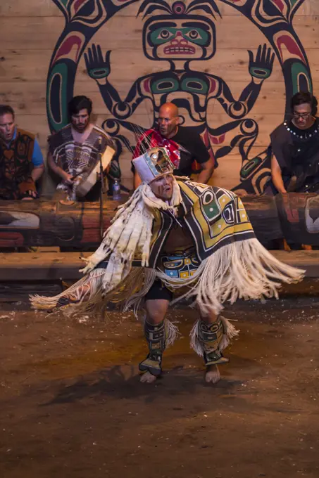 A first nation dancer performs for an audience during aboriginal days at the Komok's bighouse. Comox, The Comox Valley, Vancouver Island, British Columbia, Canada