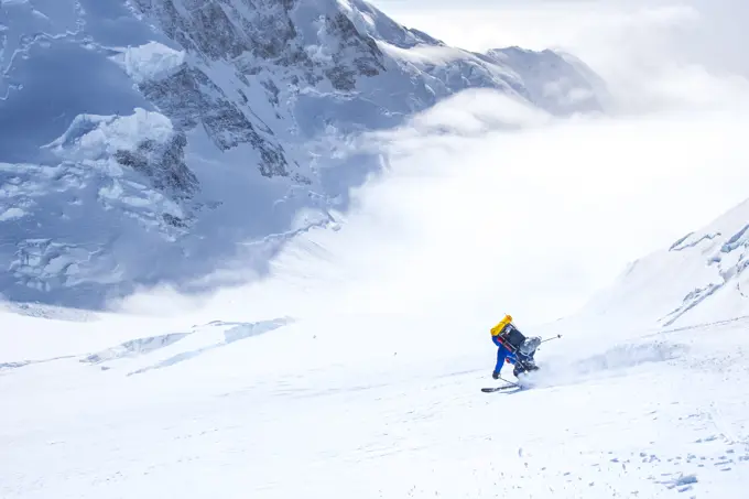 A skier descends the King's Trench route on Yukon's Mount Logan (Canada's highest peak), with King's Peak towering behind.