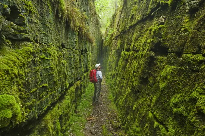 hiker along limestone fissures, Lake Winnipeg, Manitoba, Canada