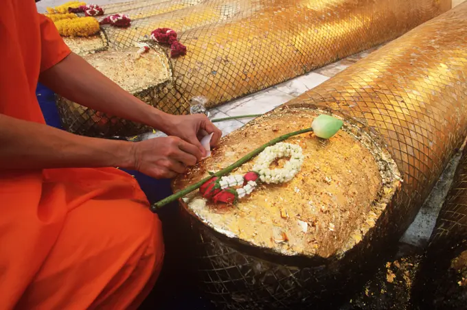 South East Asia, Thailand, Bangkok, Monks places offering at Buddha statue feet. Wat Indrawahim