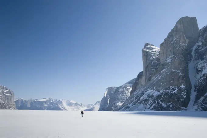 Hiker on sea ice of Sam Ford Fiord, Baffin Island, Nunavut, Canada