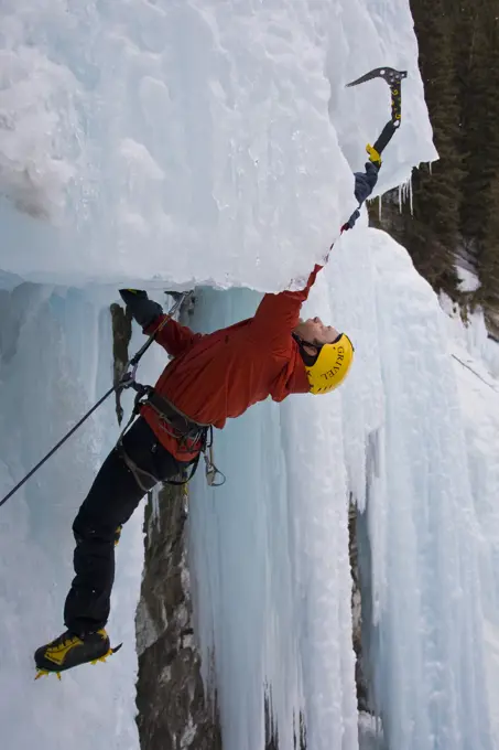 A male ice clmber tackles some steep ice in Johnstone Canyon, Banff National Park, AB