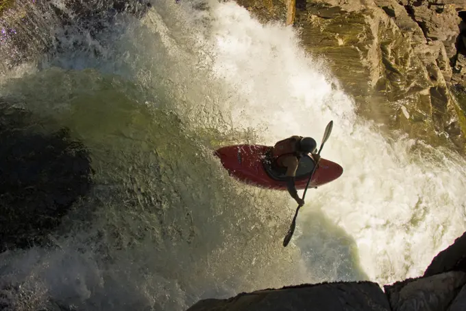 A male kayaker paddles off Raft Falls, Clearwater, British Columbia, Canada