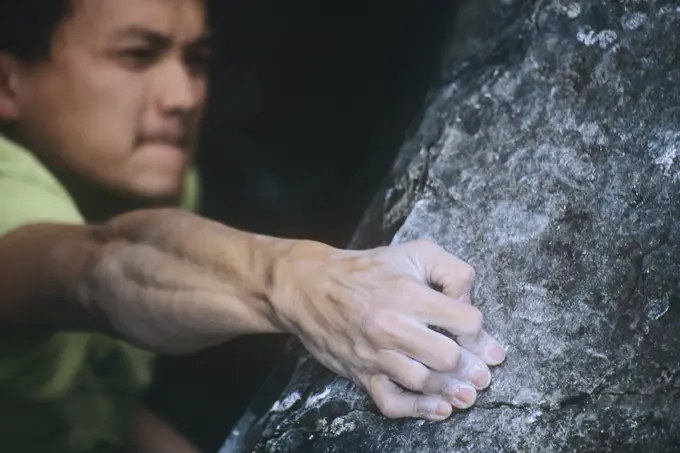 Man rock climbing a V7 in the Cathedral Forest, British Columbia, Canada.