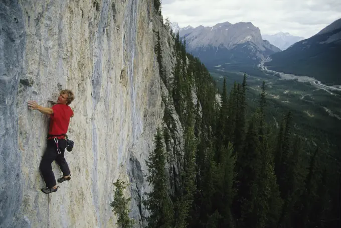a young man leading up a route called Weapons of Mass Destruction in Spray Lakes, Alberta, Canada.