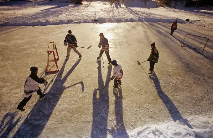 Boys playing hockey on outdoor rink, Winnipeg, Manitoba, Canada.