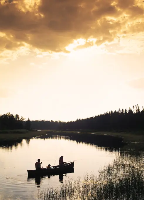 Silhouette of family canoeing and fishing, Whiteshell River, Whiteshell Provincial Park, Manitoba, Canada