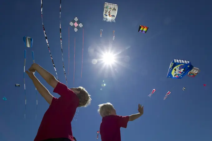 Two boys enthralled with the variety of kites at Parksville´s Kitefest, look skyward, Parksville, Central Vancouver Island, British Columbia, Canada.