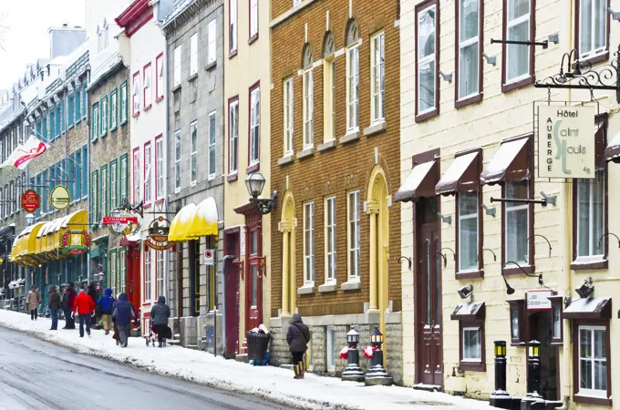 Tourists walking on an old street with Heritage commercial buildings in the Old Quebec in winter, Canada