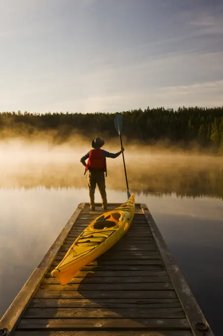 man on dock with kayak, Little Deer Lake, Lac La Ronge Provincial Park, Northern Saskatchewan, Canada