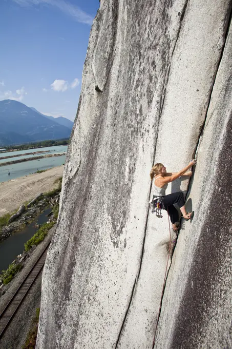 A strong female climber climbing Crescent Crack 10d, Squamish, BC