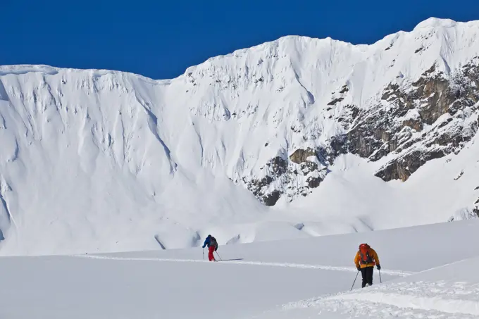 A backcountry skier and a splitboarder touring at Icefall Lodge, Canadian Rockies, Golden, BC