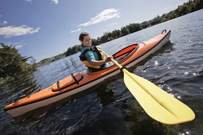 Woman kayaking on Lake Micmac in Dartmouth, Nova Scotia, part of Halifax Regional Municipality.