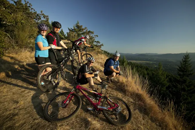 A group of friends stop for a rest on Mt. Tzoulalem, Duncan, Central Vancouver Island, British Columbia, Canada