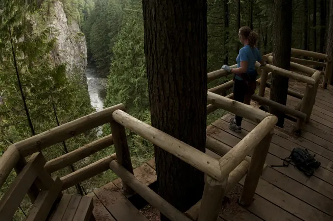 Woman trail running on the Capilano Pacific Trail, Capilano River Regional Park, North Vancouver, British Columbia, Canada